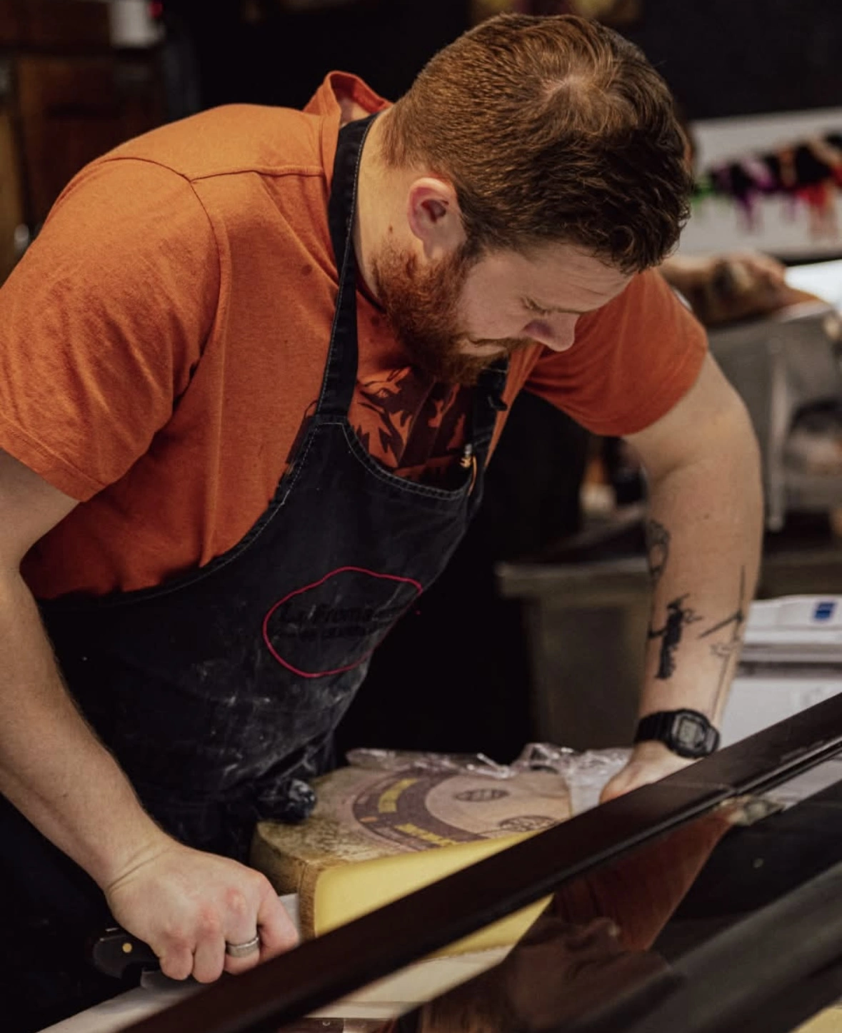 l'image d'un homme en train de couper du fromage.